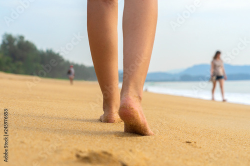A young girl is walking along a deserted beach.
