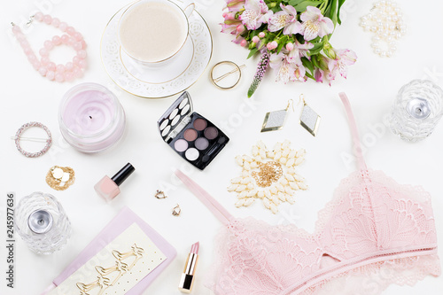 Feminine flat lay with woman fashion accessories, lingerie, jewelry, cosmetics, coffee and flowers. Top view