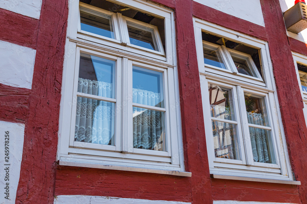 Fototapeta premium Two windows on the facade of ancient half-timbered house