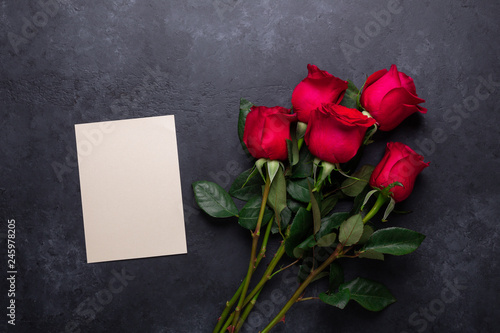 Red rose flowers bouquet on black stone background Valentine's day greeting card Top view Copy space