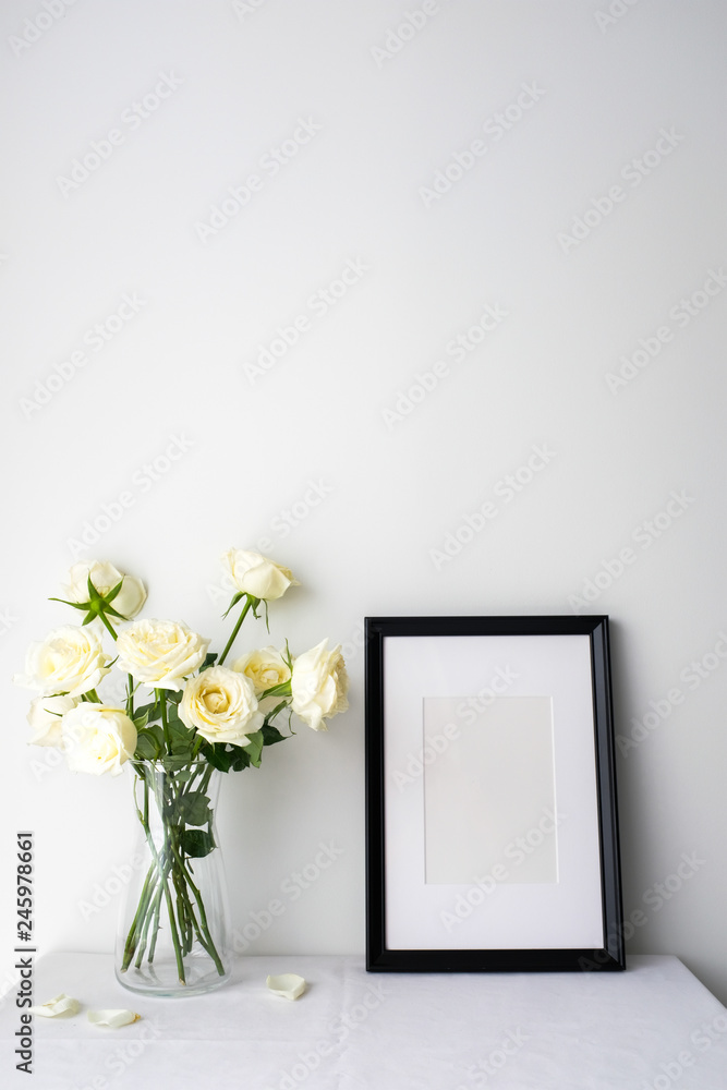 White roses in a glass vase on white table top on white background with copy space for product mockup placement for valentine's day wedding ceremony White roses in a glass vase on white table top on white background with copy space for product mockup placement for valentine's day wedding ceremony