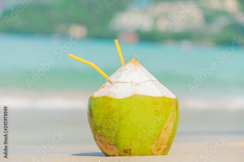 Fresh coconut on a sunny beach background.