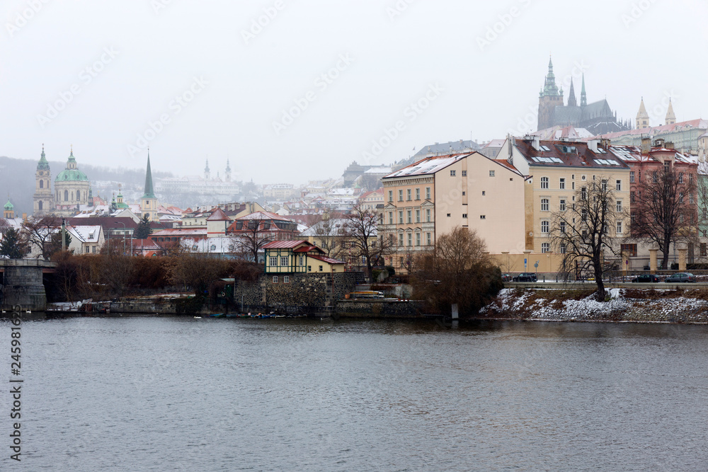 Snowy foggy Prague Lesser Town with gothic Castle above River Vltava, Czech republic Snowy foggy Prague Lesser Town with gothic Castle above River Vltava, Czech republic