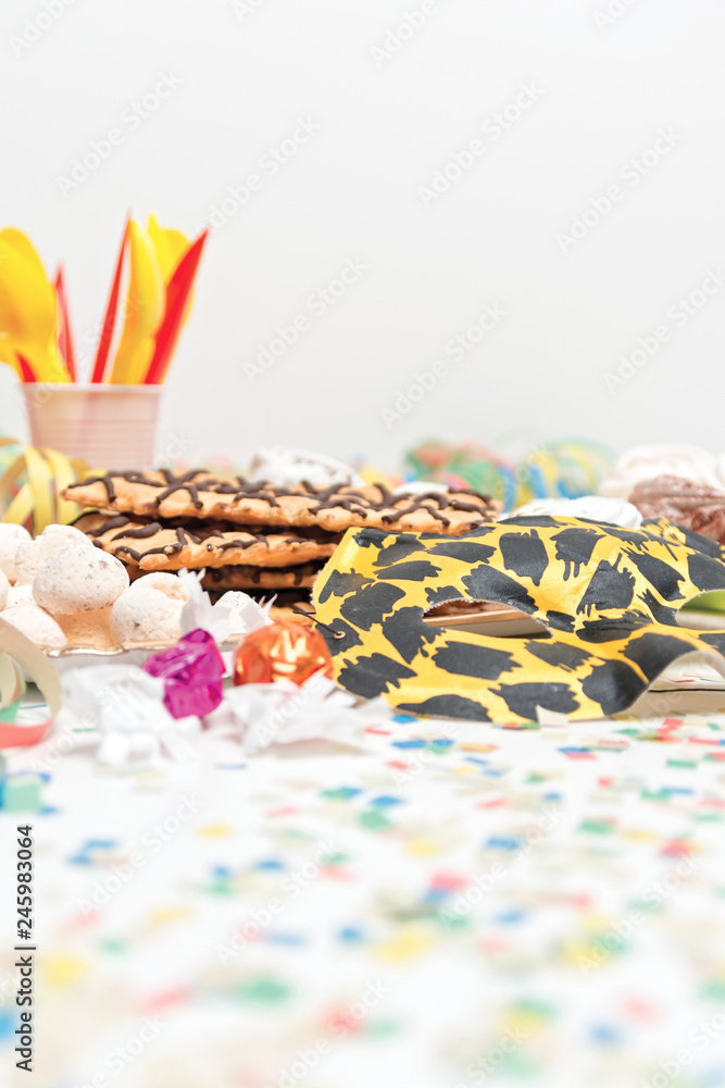 Fototapeta premium frittelle di carnevale con mascherina e coriandoli dal basso verticale