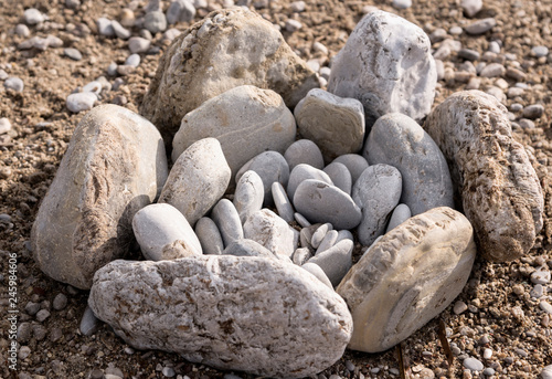 the composition of gray stones of different sizes in the form of a flower on the beach