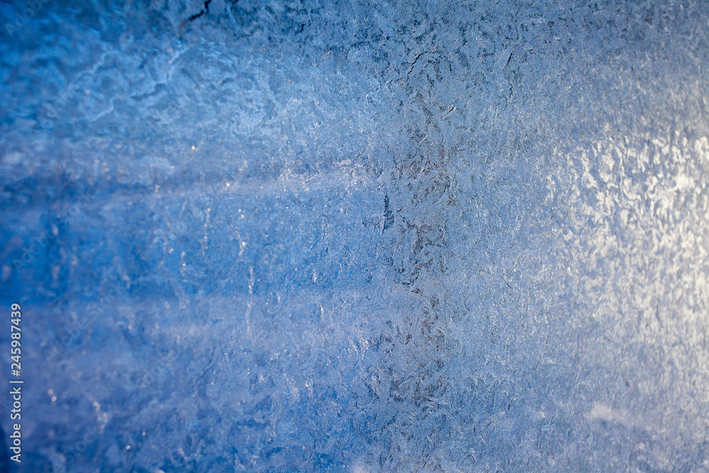 winter patterns on glass. Ornate frost pattern on frosted window as Christmas background winter patterns on glass. Ornate frost pattern on frosted window as Christmas background