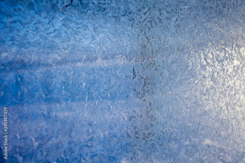 winter patterns on glass. Ornate frost pattern on frosted window as Christmas background