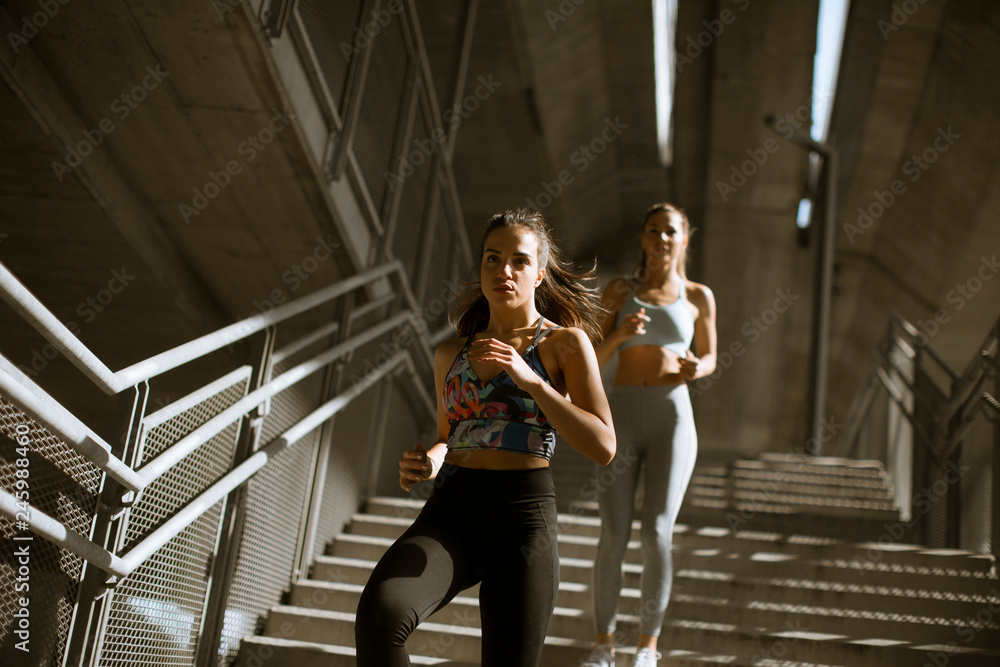 Two young woman workout in urban environment
