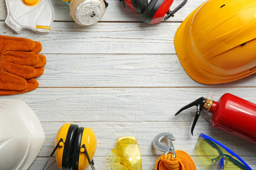 Flat lay composition with safety equipment and space for text on wooden background
