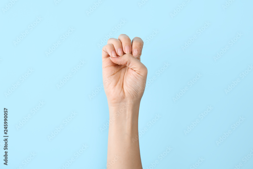 Woman showing E letter on color background, closeup. Sign language Woman showing E letter on color background, closeup. Sign language
