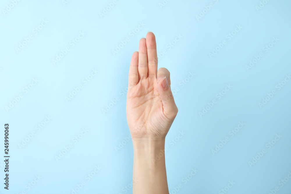 Woman showing F letter on color background, closeup. Sign language Woman showing F letter on color background, closeup. Sign language