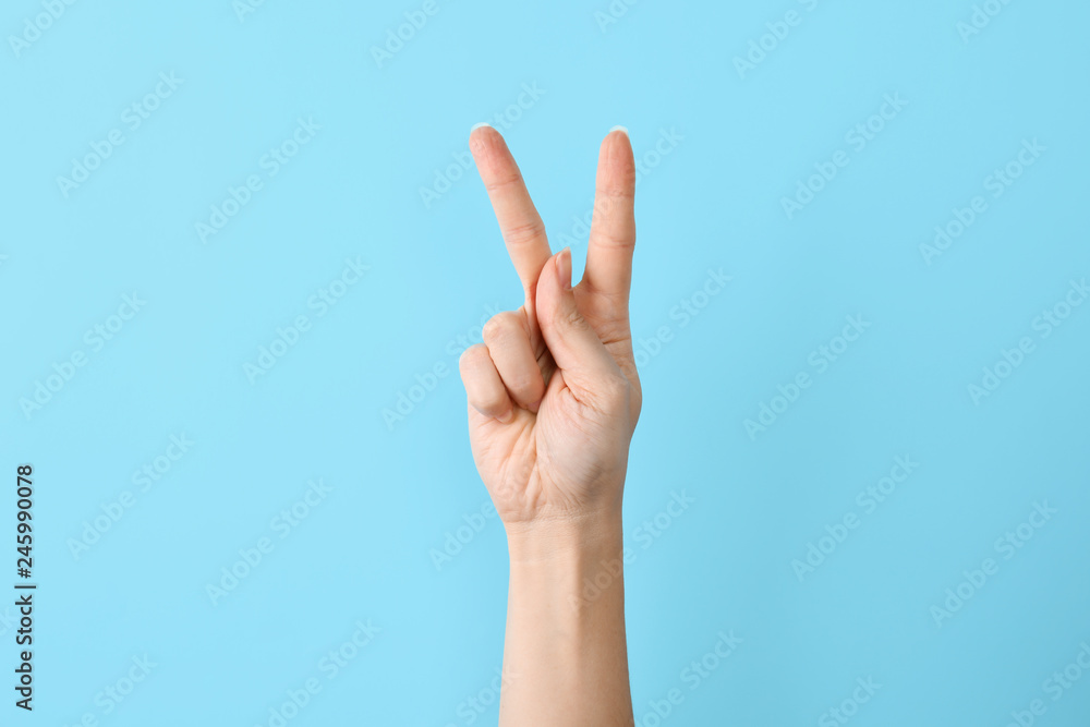 Woman showing K letter on color background, closeup. Sign language Woman showing K letter on color background, closeup. Sign language