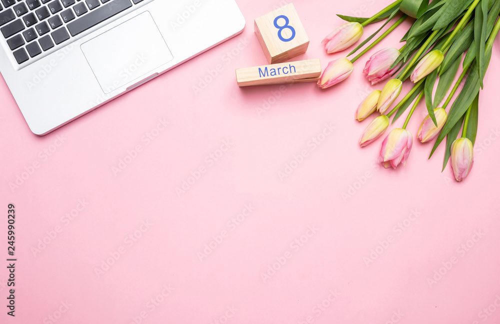 Pink tulips bouquet, date March 8th and laptop on pink background, top view, copy space Pink tulips bouquet, date March 8th and laptop on pink background, top view, copy space