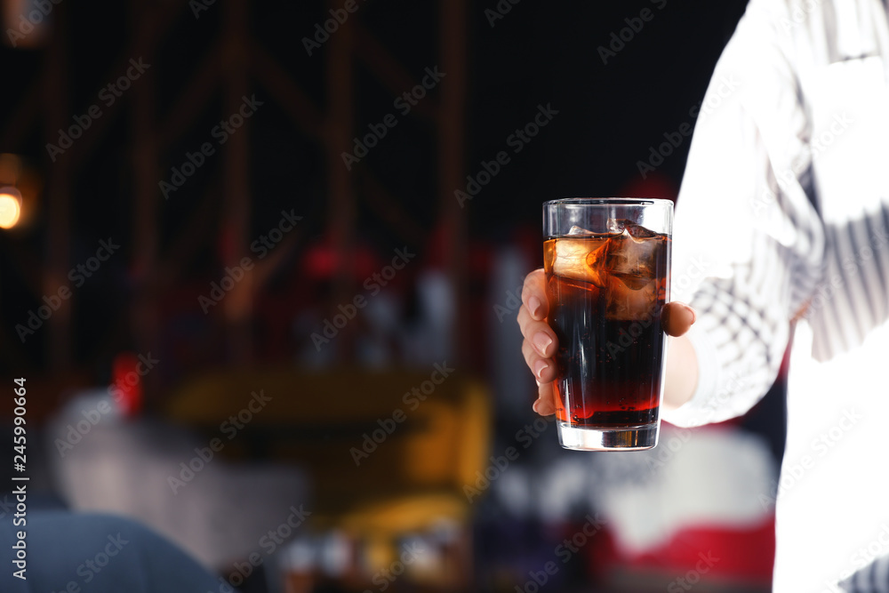 Woman with glass of refreshing cola indoors, closeup. Space for text
