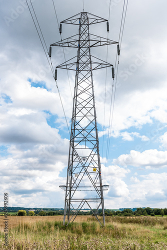 A power pylon in the countryside with blue skies