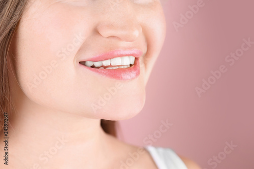 Young woman with beautiful smile on color background  closeup. Space for text