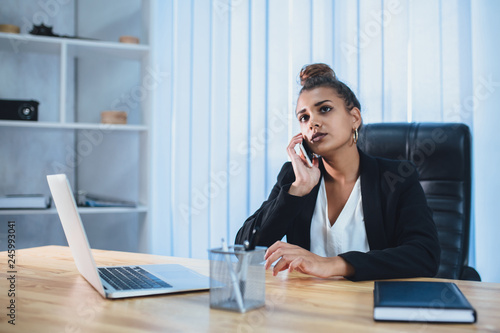 Young pretty smart business girl works in the office. During this time, she received a call with the task. © Andrii