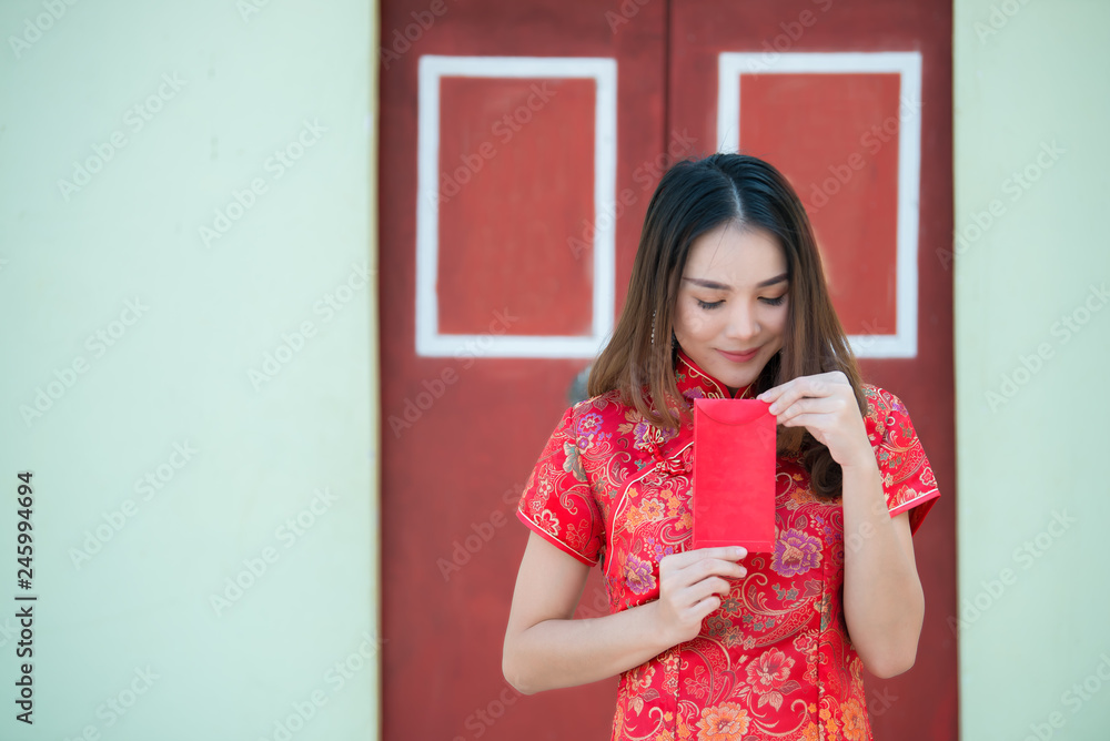 Portrait of beautiful asian woman in Cheongsam dress,Thailand people,Happy Chinese new year concept,Holding red envelope red. Portrait of beautiful asian woman in Cheongsam dress,Thailand people,Happy Chinese new year concept,Holding red envelope red.