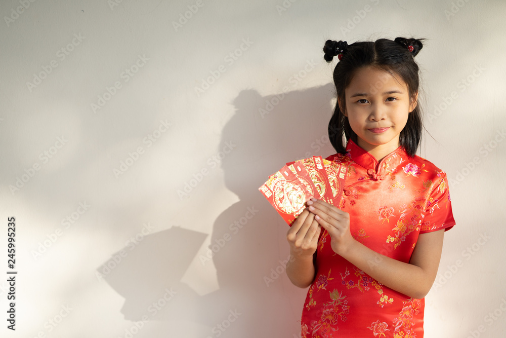 Chinese children in traditional costume holding red packet of money and smiling. Chinese children in traditional costume holding red packet of money and smiling.
