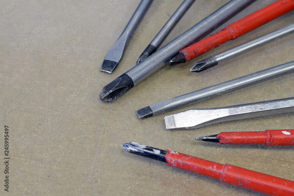 Many screwdrivers on a scratched surface. Close up image with copy space. Many screwdrivers on a scratched surface. Close up image with copy space.