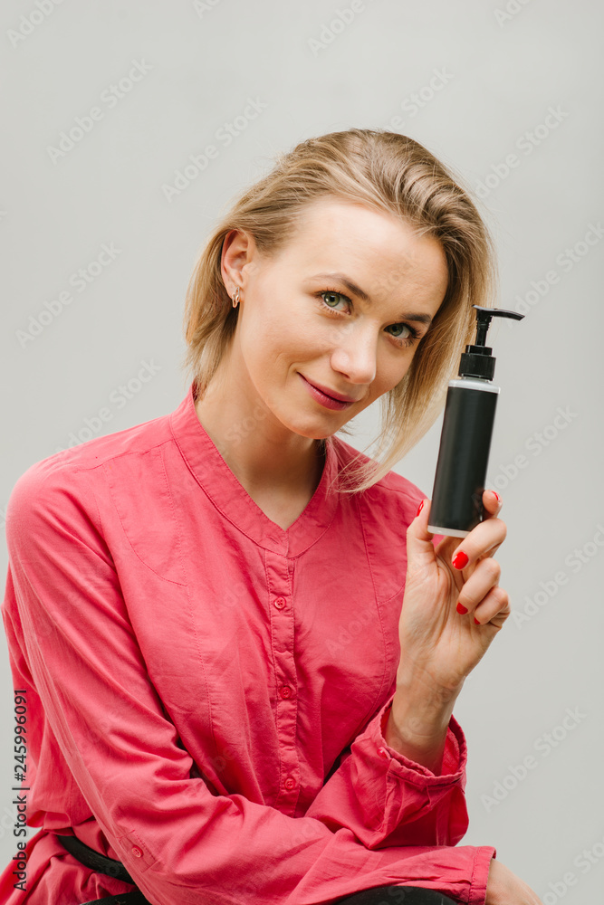 portrait of female with cosmetics bottle in hand portrait of female with cosmetics bottle in hand