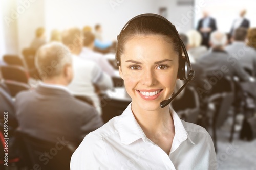 Beautiful businesswoman portrait with headset , colleagues on