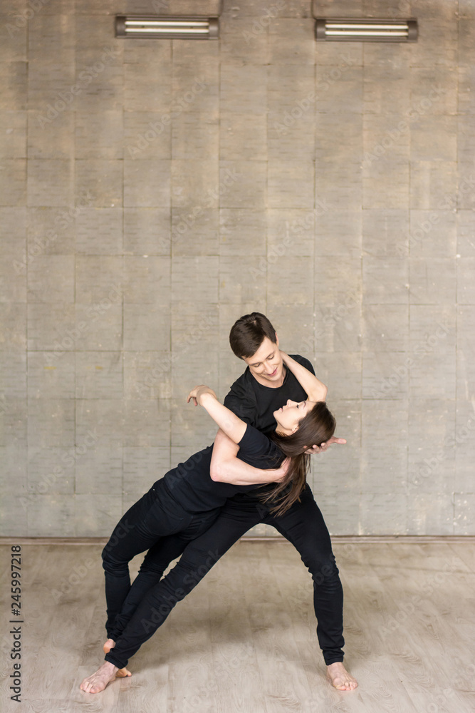 Young couple performing romantic dance. Boy gently holding his dancing