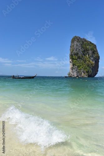 Beautiful big rock at Poda Island and a wooden long tail boat in Krabi, Thailand, Asia