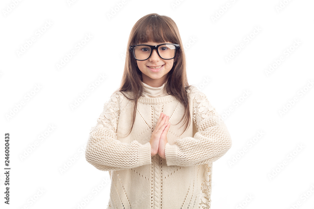 Greeting in Asian! Portrait of a little girl of 7 years with glasses cupped her hands in front of her as a sign of Asian welcome, isolated on white background.