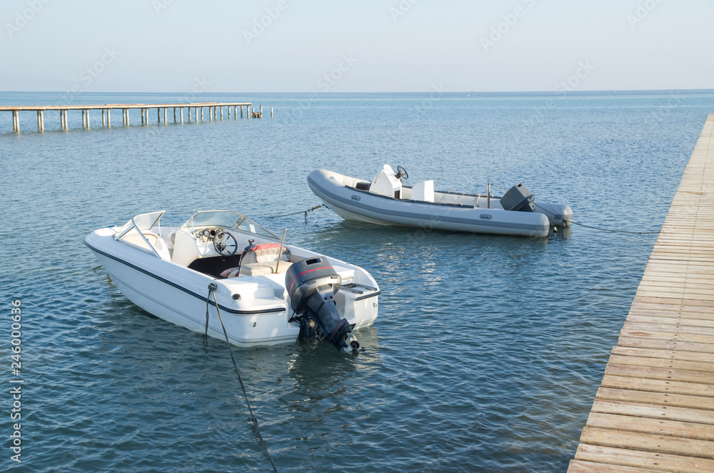 Two anchored boats in the sea near the piers in Hurgada