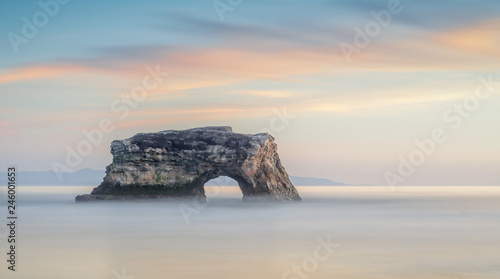 Winter sunset over the last remaining Natural Bridge. Natural Bridges State Beach, Santa Cruz, California, USA.