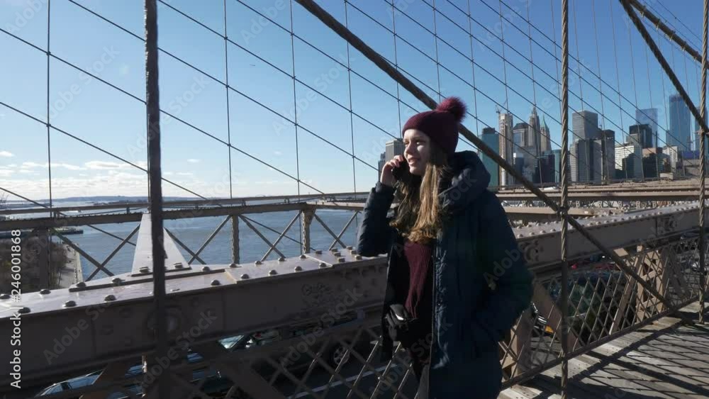 Two friends in New York walk over the famous Brooklyn Bridge Two friends in New York walk over the famous Brooklyn Bridge