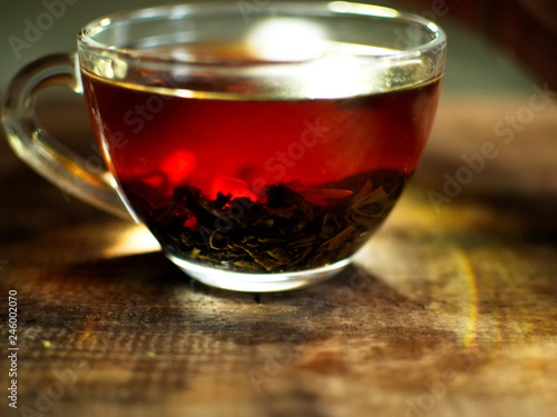 Transparent cup of golden strong tea. Glass cup with tea.