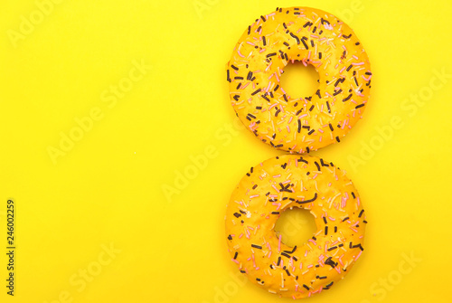 Delicious donut on yellow background with copyspace.
