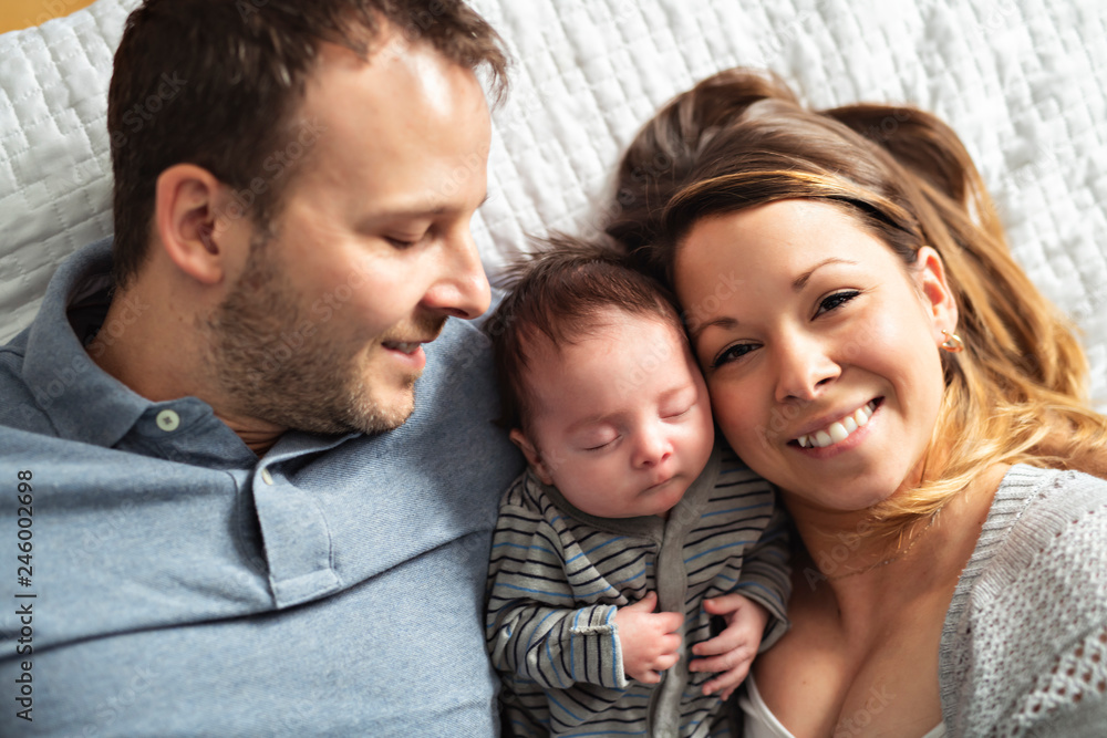 A beautiful couple with newborn Baby on bed.