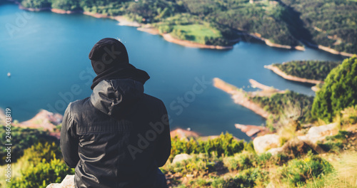 tourist traveler sits top mountain and enjoys river, hiker looking on blue sky clouds, background nature panoramic landscape in trip, relax holiday mockup concept in trekking trip