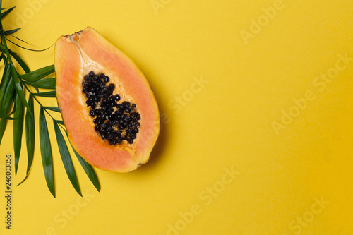 Half fresh ripe papaya on yellow background