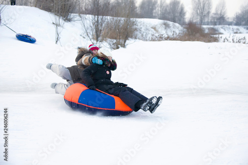 Belarus, the city of Gomel, January 07, 2018.Child sledding cheesecake.Sledding off a snow slide.Kids are sleeping on toboggan