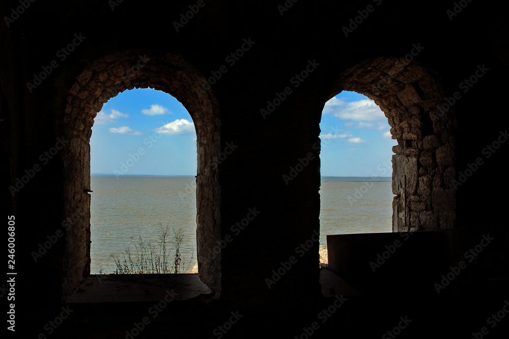 Old arched castle windows with a view on sea