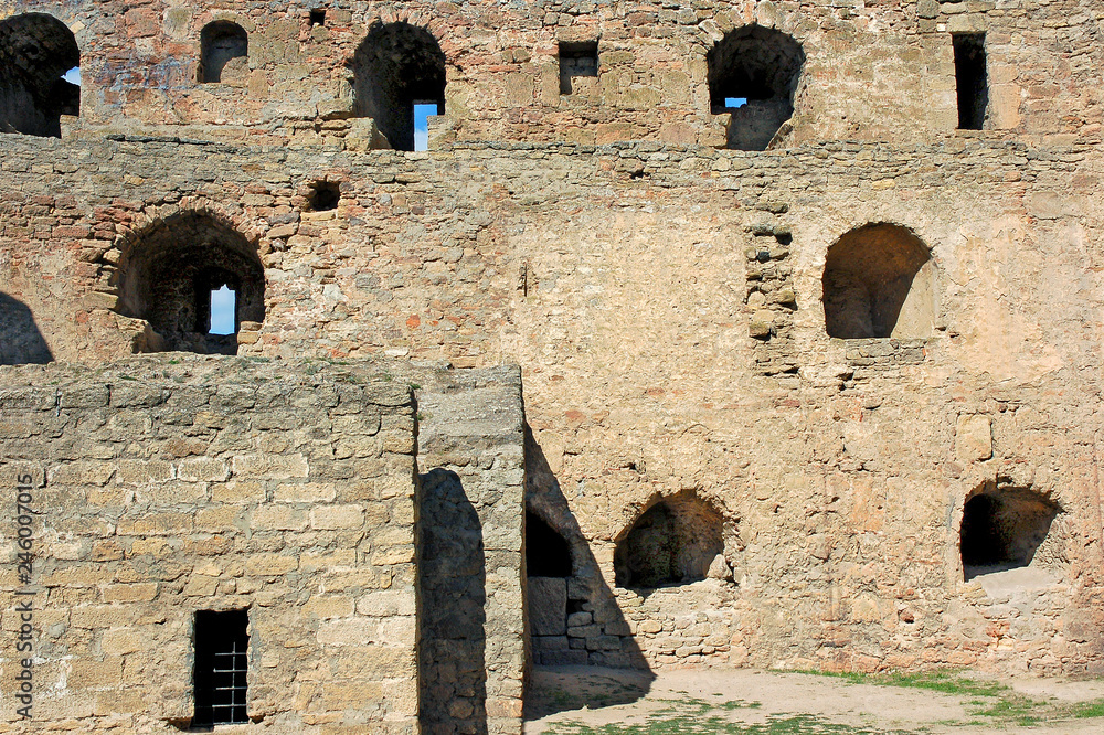 Windows and loopholes of various sizes and layouts in the medieval stone wall.
