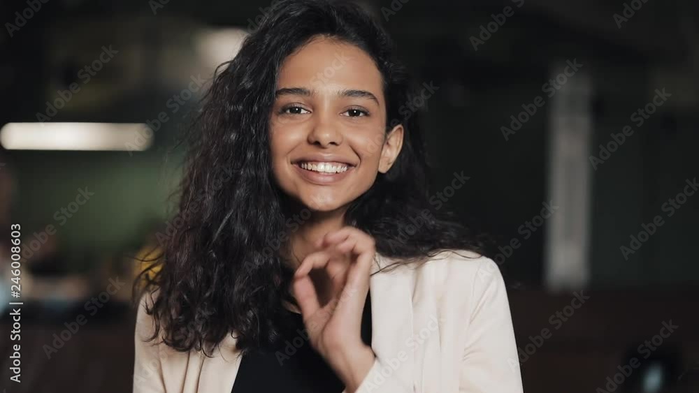 Attractive young woman looking and posing into the camera smiling feel happy in cozy coffee shop. Close up Attractive young woman looking and posing into the camera smiling feel happy in cozy coffee shop. Close up