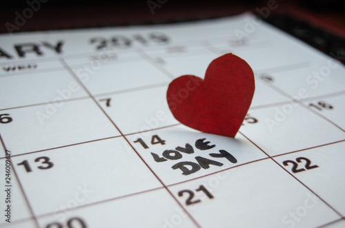 Love day - Paper red hearts marking 14 february Valentines day on white calendar