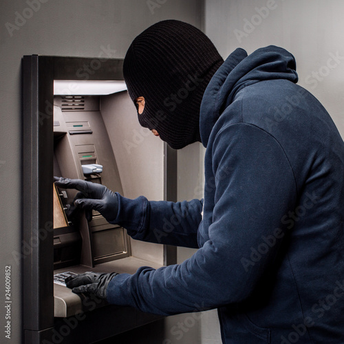 Hacker stealing password and identity on atm machine. Computer crime concept.