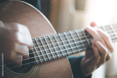 Musician is playing a classical guitar, fretboard and fingers