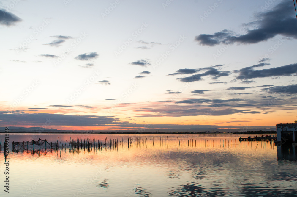 Beautiful orange sunset on one day cloudy in the famous lake of the albufera of Valencia, Spain.