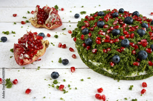 Ciasto "zielony mech" ze szpinakiem ozdobione pestkami granatu i jagodami