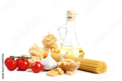 Different pasta with garlic, tomatoes and oil in bottle on white background