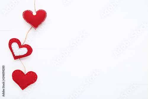Red fabric hearts on white wooden table