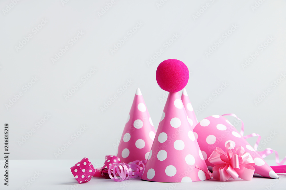 Birthday paper caps with blowers and ribbons on grey background Birthday paper caps with blowers and ribbons on grey background