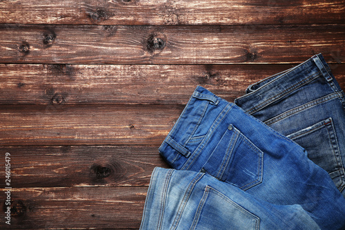 Folded jeans on brown wooden table